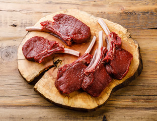 Raw sliced Venison Ribs on wooden background