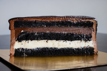 A piece of chocolate cake on a golden backing.