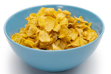 Golden cornflakes in the blue bowl isolated on white background
