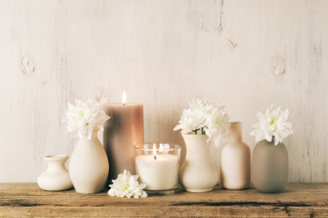 White flowers in neutral colored vases and candles