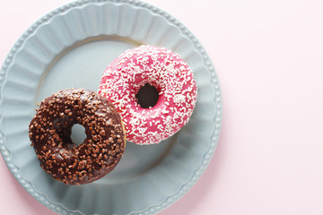 sweet donuts on plate on a colored background