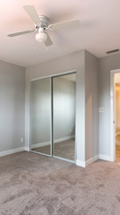 Vertical frame Empty bedroom with closet and ceiling fan