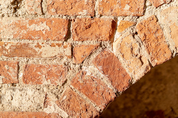 Element of old red brick arch wall in sunny day. Perfect textured grunge background. Copy space.