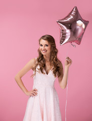 Young woman holding star shaped balloon