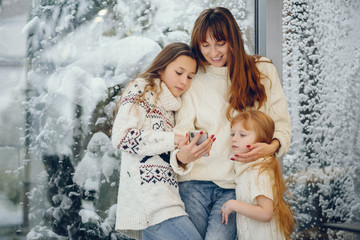 Beautiful mother with children. Family at home. People standing near winter windows