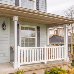 Square Exterior of home with glass panels on front door and stairs going to the porch