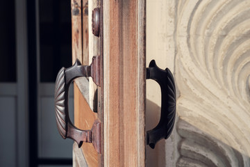 Detail of wooden door with old metal door handles