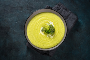 Broccoli cream soup in the bowl on dark table.