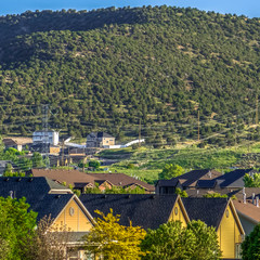 Square frame Sunny view of houses on a residential area with mountain and blue sky background