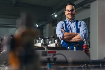 Cheerful factory worker with arms crossed.