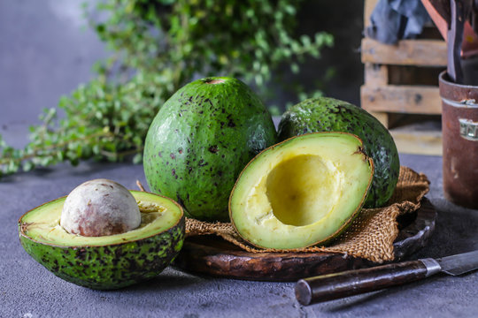 Photo of ripe organic avocado on dark background. Wooden table. Nutritious Fruit. Healthy food concept. Tropical fruit. Copy space. Green. Image