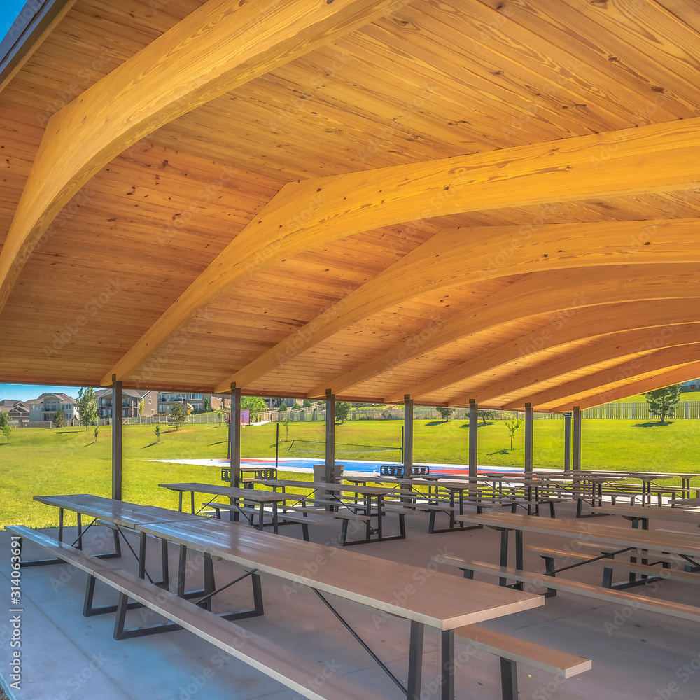 Wall mural Square frame Park pavilion with white tables and seats under the brown wooden ceiling