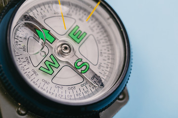 metal navigation travel compass on a blue background. search for a way. point of view
