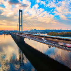 Automobile and railroad bridge in Kiev, the capital of Ukraine. Bridge at sunset across the Dnieper River. Kiev bridge against the backdrop of a beautiful sunset in Kiev. Bridge in evening sunshine