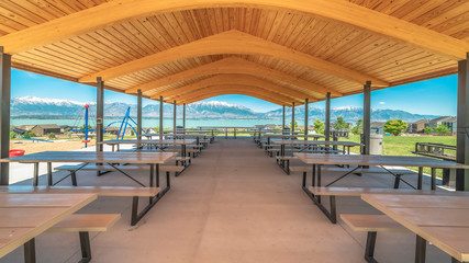 Pano Pavilion with brown wooden ceiling overlooking lake and snow capped mountain