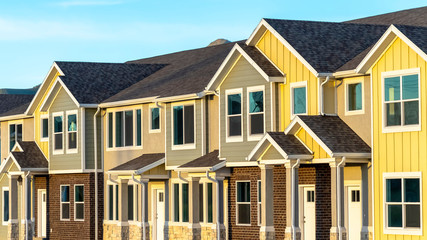 Pano frame Exterior view of townhomes with gable roof stairs and square columns at entrance