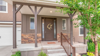 Fototapeta premium Pano frame Home with stairs leading to porch and door flanked with sidelights and windows