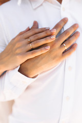 Obraz na płótnie Canvas Hands with couple rings on their wedding day on an island