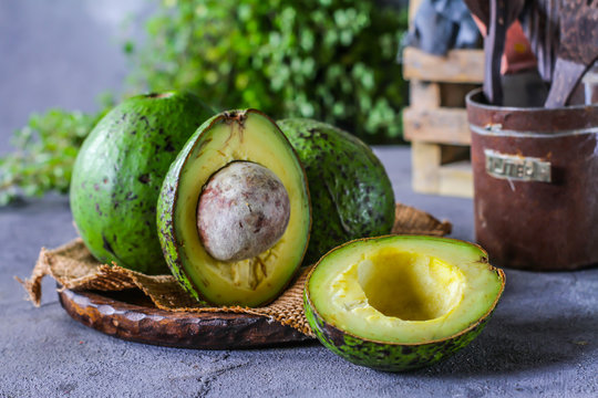 Photo of ripe organic avocado on dark background. Wooden table. Nutritious Fruit. Healthy food concept. Tropical fruit. Copy space. Green. Image
