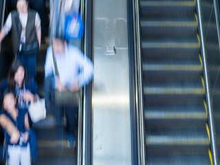 People rush on escalator motion blurred