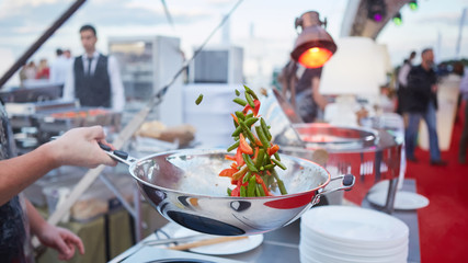 chef tossing vegetables in a wok