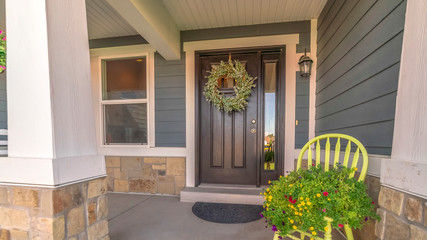 Pano frame Porch and facade of home decorated with colorful flowers and wreath on the door