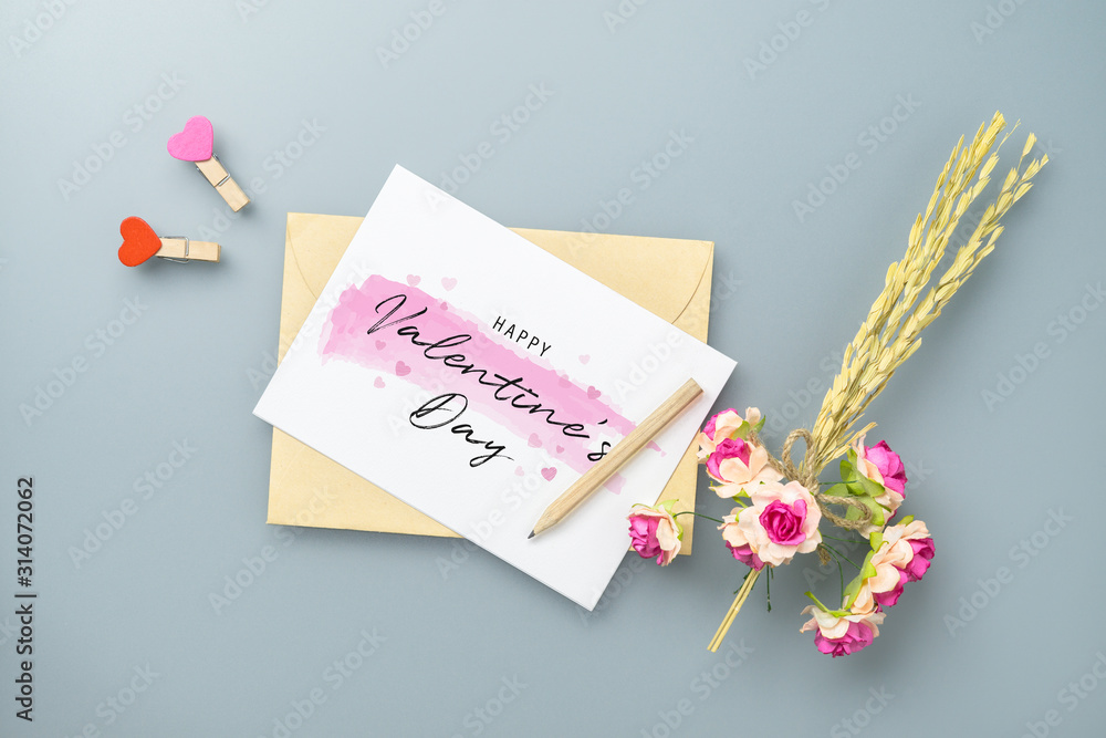 Aufkleber mockup blank postcard and envelope on grey table background with craft rose flower. mock up for eleg
