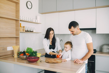 Family in a kitchen. Beautiful mother with little son. Father in a white t-shirt.