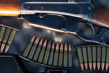 Close up of a vintage rifle in a case, next to ammunition