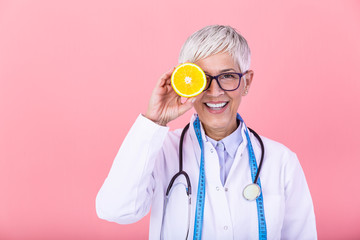 Dietician holding an orange. Smiling nutritionist holding a sliced orange, vitamins and healthy...