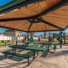 Square frame Empty green tables and benches in an urban park