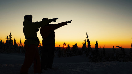 people silhouettes admire pictorial sunset and raise hands
