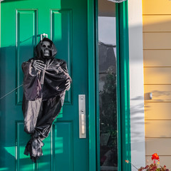 Square A grim reaper decoration on a green front door