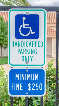 Vertical frame Handicapped parking only sign on fence on cloudy day