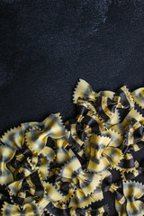 pasta farfalle with cuttlefish ink (healthy eating, black multi-colored) menu concept. food background. top view. copy space