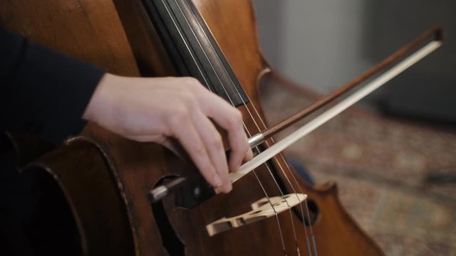 Musician Close Up View Of Bow On The Strings Of Cello