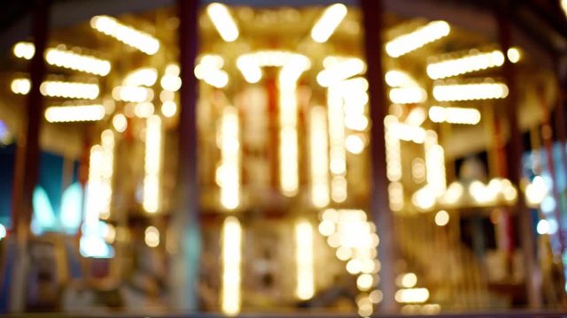 night abstract blurred illuminated carousel with city lighs. city street illumination christmass time. focus movement