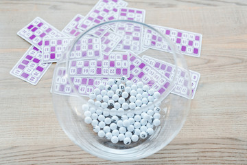 selective focus of glass bowl with balls near purple lottery tickets