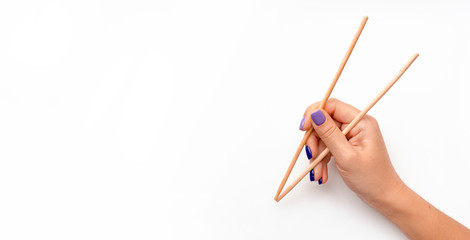 Girl holding chopsticks for roll. Female hand