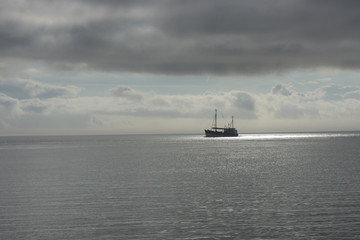 Fisherman boota on the North Sea with sun spot from the clouds