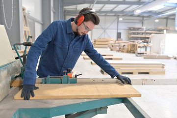 Apprentice working wood in carpentry workshop
