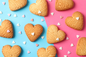 Heart shaped cookies on color background with hearts, top view