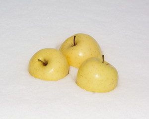 Yellow apples on white snow close-up