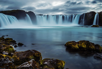 Fototapeta premium Cascades of waterfalls dropping down from the cliffs. Long exposure. tslandtya. A beautiful waterfall, frozen motion of water streams on a long exposure. The most visited waterfall in Iceland. Waterfa