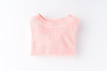 Pink folded sweater isolated on white background. Flat lay. Top view