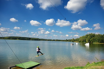 Wakeboarder making tricks. Low angle shot of man wakeboarding