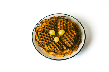 Homemade heart shaped waffles on plate served with grapes. freshly baked heart shaped Belgium waffles isolated on white background