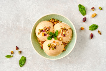 Ice cream with pistachio in ceramic bowl on wooden board 