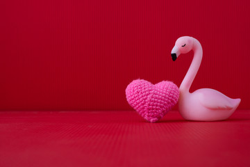 Copy space on Red Valentines background with Pink Alone bird toy.
