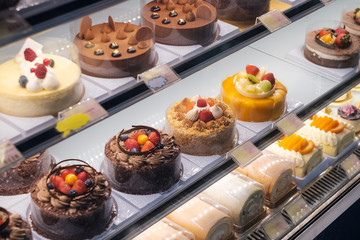 sweets and cakes on display in bakery shop -